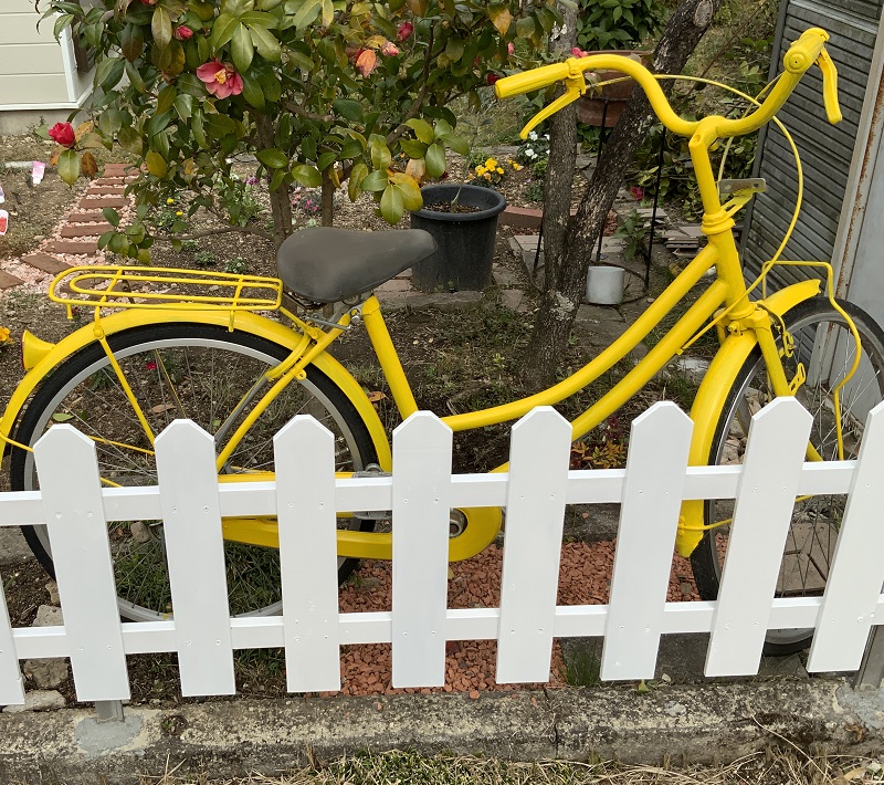 白いフェンスと黄色い自転車